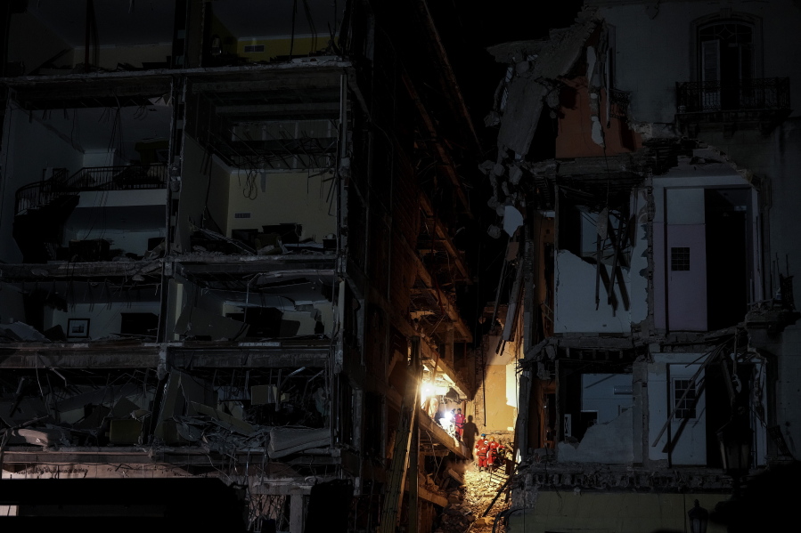 Members of a rescue team search through the rubble at the site of a deadly explosion that destroyed the five-star Hotel Saratoga in Old Havana, Cuba, Sunday, May 8, 2022.
