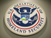 FILE - Homeland Security logo is seen during a joint news conference in Washington, Feb. 25, 2015. The Department of Homeland Security paused the work of its new disinformation governance board Wednesday. The move responds to weeks of criticism from Republicans and questions about whether the board would impinge on Americans' free speech rights. A statement says DHS' advisory board on homeland security will review the board's work.