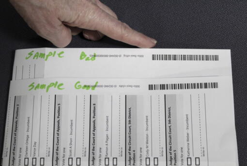 An election worker at the Clackamas County Elections office shows barcodes on ballots that is bad, top, and good on Thursday, May 19, 2022, Oregon City, Ore. Ballots with blurry barcodes that can't be read by vote-counting machines will delay election results by weeks in a key U.S. House race in Oregon's primary.