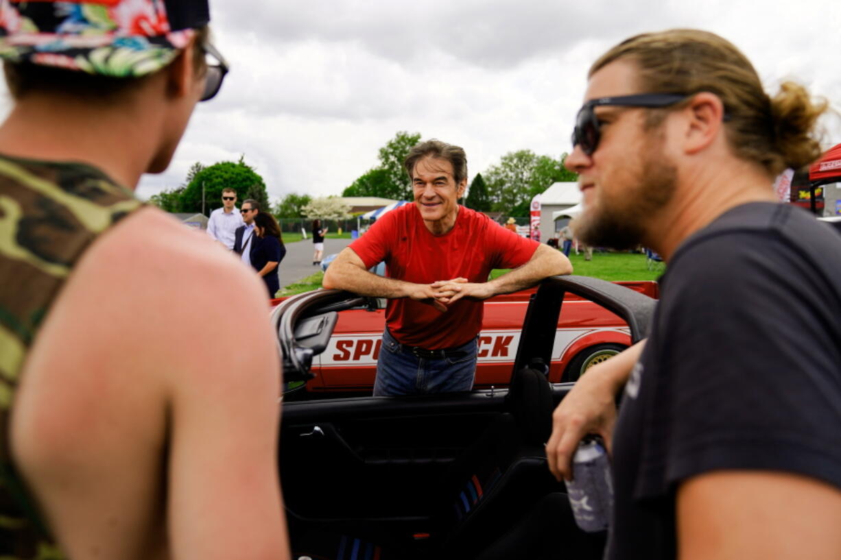 Mehmet Oz, a Republican candidate for U.S. Senate in Pennsylvania, meets with attendees during a visit to a car show in Carlisle, Pa., Saturday, May 14, 2022.