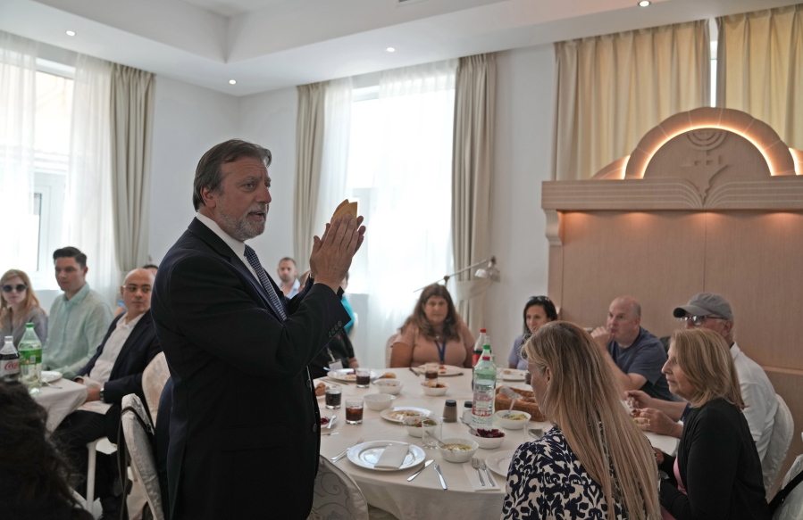 Rabbi Elie Abadie says a blessing as he hosts a lunch for a Jewish business delegation at a villa that serves as a temporary synagogue for his congregation in Dubai, United Arab Emirates, Tuesday, May 10, 2022. The fast-growing population of Jewish immigrants to the United Arab Emirates may feel freer than ever to express their identity in the autocratic Arab sheikhdom, which has sought to brand itself as an oasis of religious tolerance. But plans to build a permanent Jewish sanctuary for Dubai's fast-expanding congregation have sputtered to a standstill, religious leaders say.
