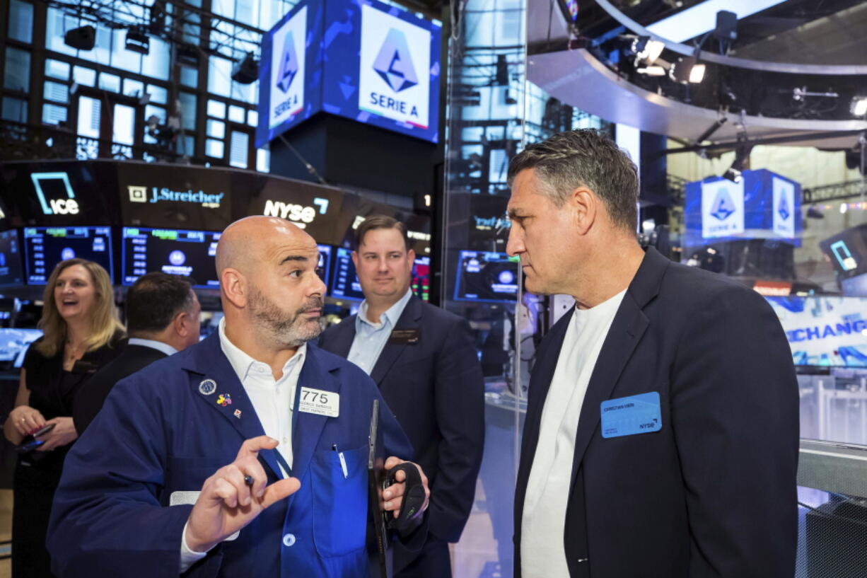 In this photo provided by the New York Stock Exchange, trader Fred DeMarco, left, talks with Christian Vieri, right, on the trading floor during the visit of a delegation of Lega Serie A executives and owners to the NYSE, Tuesday, May 24, 2022.