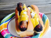 Yellow mustard on top of a pair of grilled hotdogs. Mustards are made around the world and with all kinds of ingredients besides mustard seeds. Try picking up local mustards when you travel.