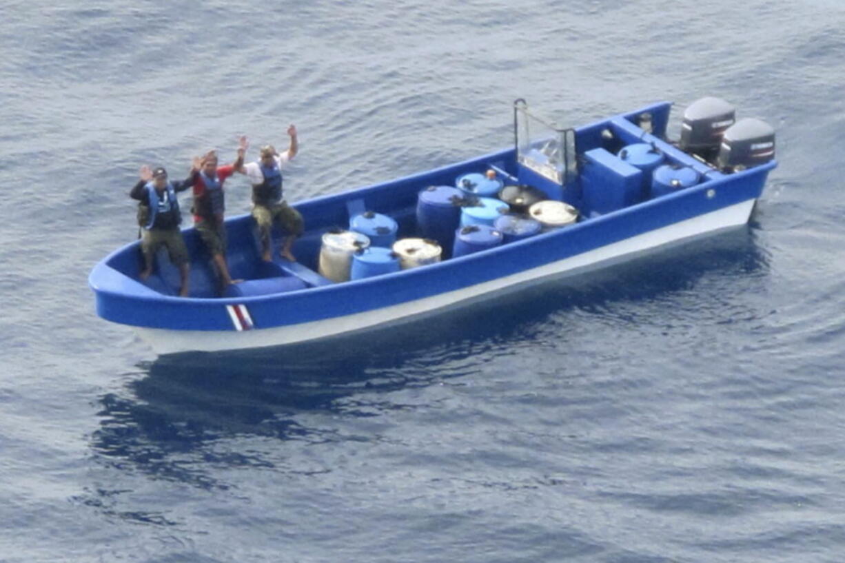 In this photo obtained from U.S. federal court records, Jeffri D?vila-Reyes, third from left, and two others hold their hands in the air as they are intercepted in the Caribbean Sea on Oct. 29, 2015. D?vila-Reyes says he's still mystified how he ended up serving hard time in a U.S. federal prison. His cocaine bust at sea was closer to his homeland of Costa Rica than the United States, and the few kilos of drugs he was carrying were bound for Jamaica rather than American shores. (U.S.