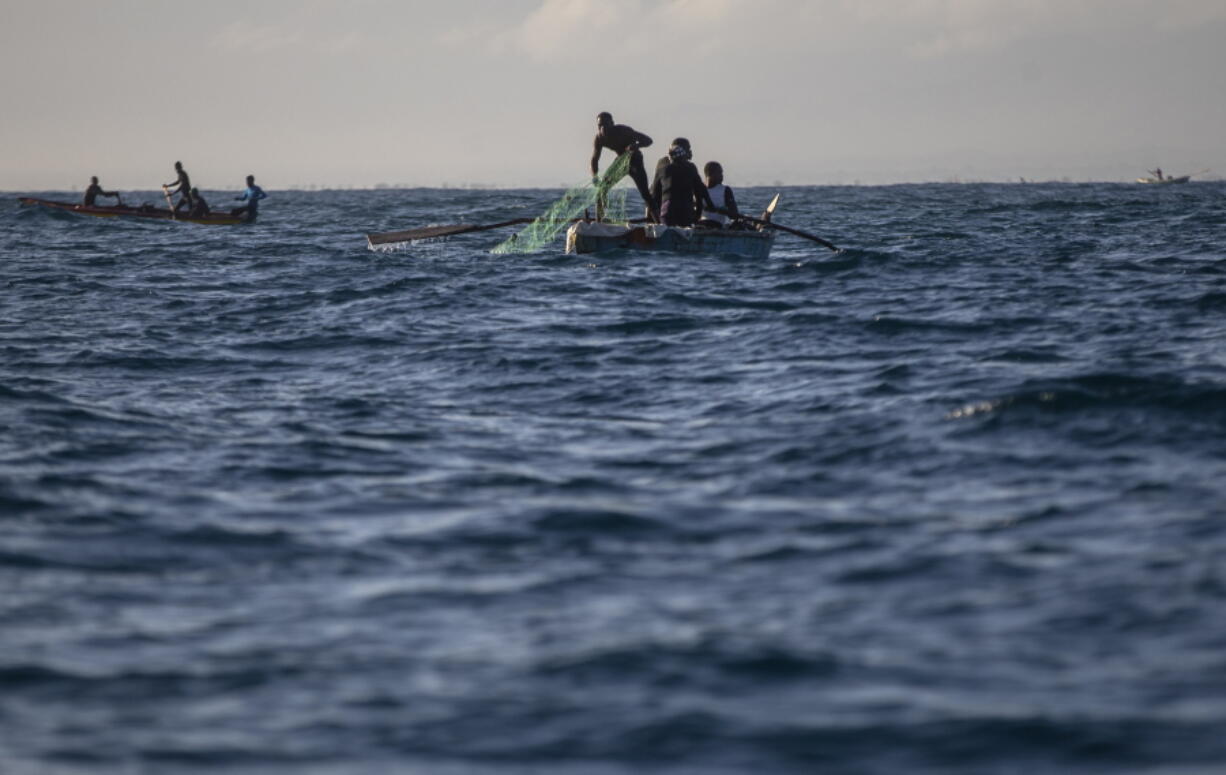 A fisherman pulls his net back onto his boat in the waters surrounding Cap-Haitien, Haiti, Friday, March 11, 2022. A prize winning marine biologist is working to bring together fishermen from Haiti and the Dominican Republic and find a solution that will not only save their livelihoods but also vital marine resources in a region under extreme pressures from climate change.