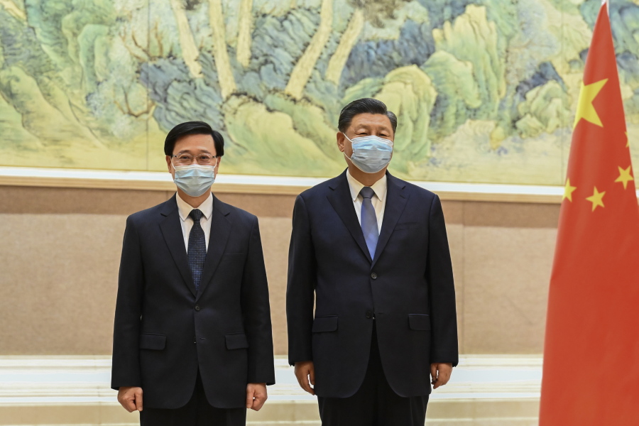 In this photo released by Xinhua News Agency, Chinese President Xi Jinping, right, and Hong Kong Chief Executive-elect John Lee pose for photo before their meeting in Beijing, Monday, May 30, 2022. Hong Kong's next leader, John Lee, has received an official letter of appointment from Beijing a month before he is to take over the leadership of the semi-autonomous city.