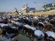 Muslim men offer Eid al-Fitr prayers to mark the end of the holy fasting month of Ramadan at Sunda Kelapa port in Jakarta, Indonesia, Monday, May 2, 2022.