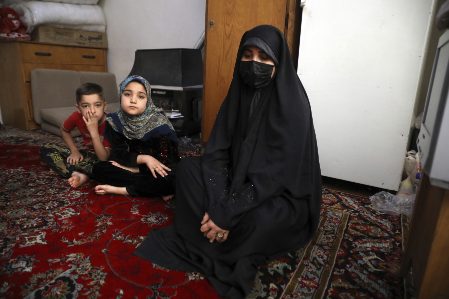 Afghan refugee Zahra Husseini and her children Salehe, center, and Shahrzad sit in their room in a poor suburb of Tehran, Iran, April 21, 2022. The Taliban members who killed her activist husband offered Husseini a deal: Marry one of us, and you'll be safe. Husseini, 31, decided to flee to Iran.