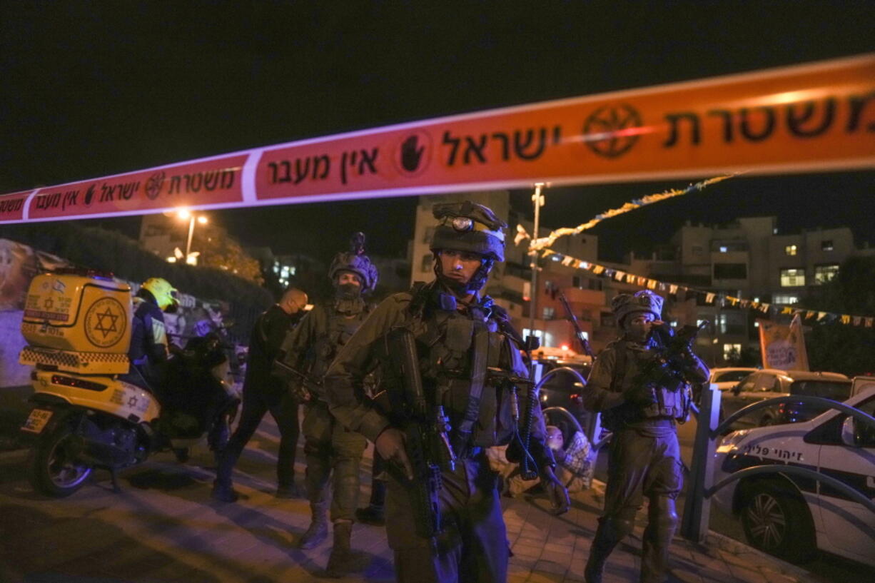 Israeli forces secure the area of a stabbing attack in the town of Elad, Israel, Thursday, May 5, 2022. Israeli medics say at least three people were killed in a stabbing attack near Tel Aviv on Thursday night. Israeli police said they suspect it was a militant attack.