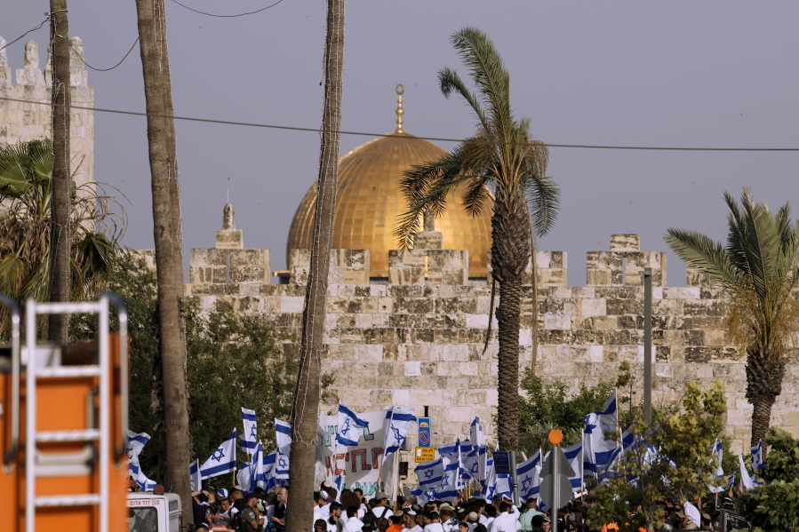 Israelis wave national flags in front of Damascus Gate outside Jerusalem's Old City to mark Jerusalem Day, an Israeli holiday celebrating the capture of the Old City during the 1967 Mideast war, Sunday, May 29, 2022. Israel claims all of Jerusalem as its capital. But Palestinians, who seek east Jerusalem as the capital of a future state, see the march as a provocation. Last year, the parade helped trigger an 11-day war between Israel and Gaza militants.