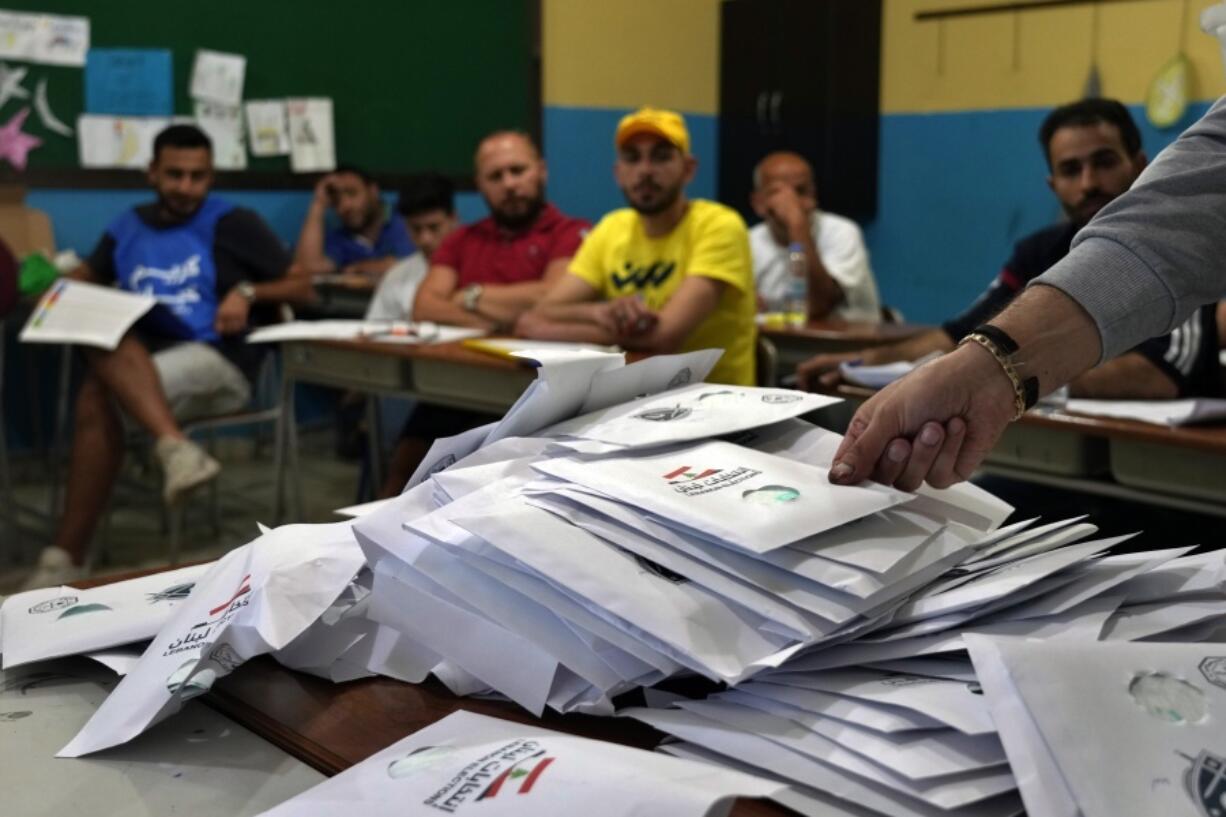 Election officials count ballots shortly after polling stations closed, in the northern city of Tripoli, Lebanon, Sunday, May 15, 2022. Lebanese voted for a new parliament Sunday against the backdrop of an economic meltdown that is transforming the country and low expectations that the election would significantly alter the political landscape.