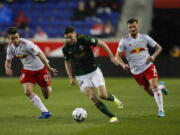 Portland Timbers forward Jaroslaw Niezgoda (11), center, tries to control the ball under the pressure of New York Red Bulls defenders Dylan Nealis (12) and Thomas Edwards (7) during the first half of an MLS soccer match, Saturday, May 7, 2022, in Harrison, N.J.