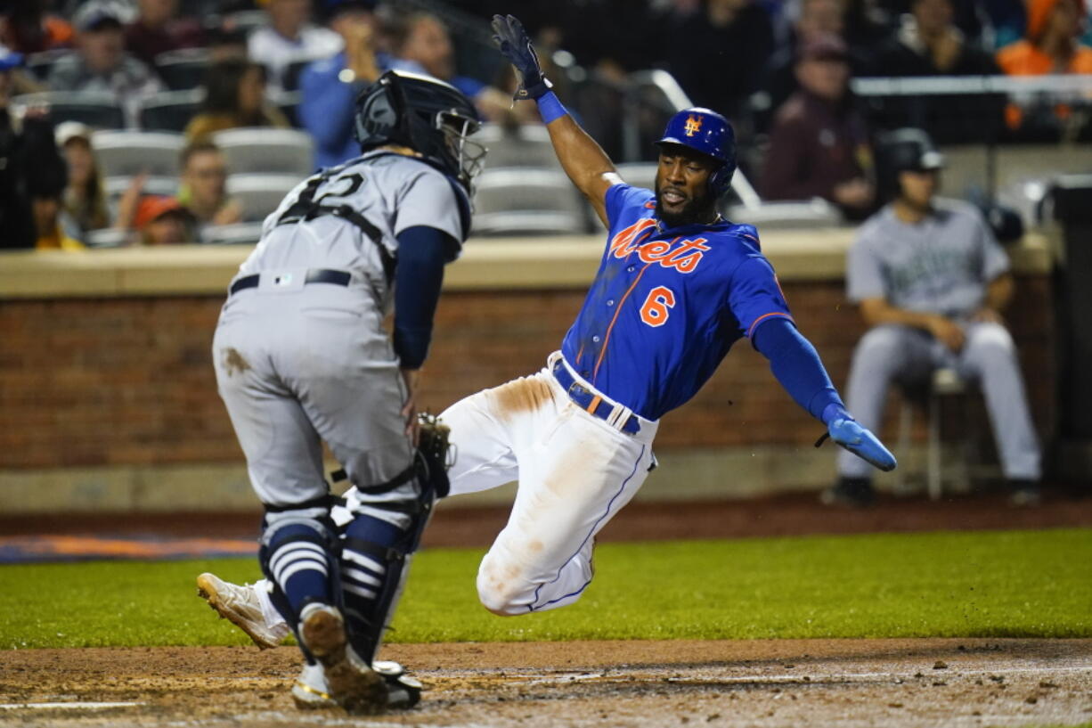 New York Mets' Starling Marte, right, slides past Seattle Mariners catcher Luis Torrens to score on a double by Pete Alonso during the fifth inning of a baseball game Saturday, May 14, 2022, in New York.
