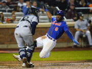 New York Mets' Starling Marte, right, slides past Seattle Mariners catcher Luis Torrens to score on a double by Pete Alonso during the fifth inning of a baseball game Saturday, May 14, 2022, in New York.