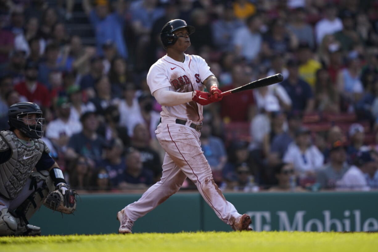 Boston Red Sox's Rafael Devers, right, watches his home run in the third inning in a baseball game against the Seattle Mariners, Saturday, May 21, 2022, in Boston. (AP Photo/Robert F.