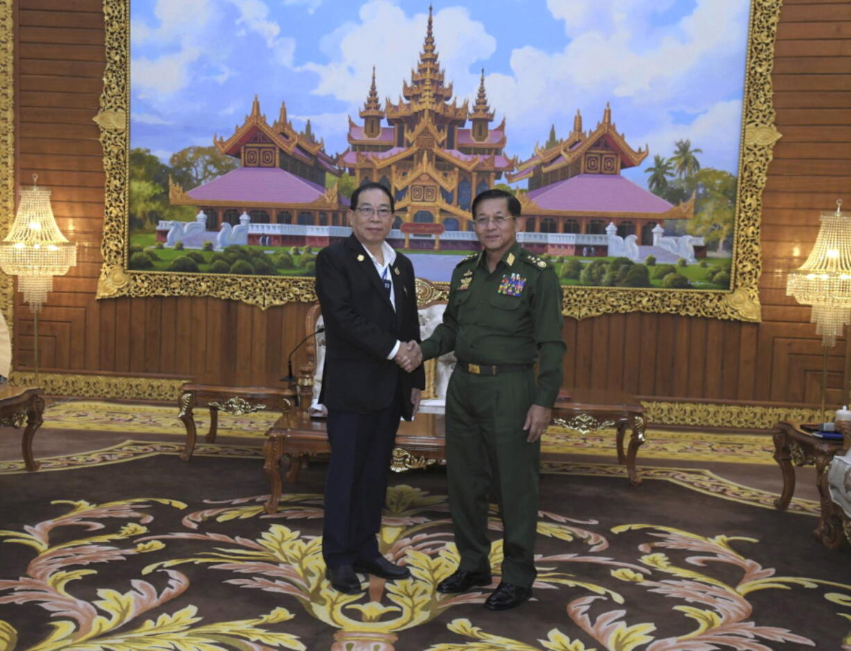 In this photo provided by the Myanmar Military True News Information Team, Senior Gen. Min Aung Hlaing, right, head of the military council, shakes hand with Yawd Serk, chairman of Shan State Army, during their meeting Friday, May 20, 2022, in Naypyitaw, Myanmar.