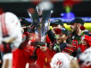 Utah players celebrate with the trophy after their victory over Oregon to win the Pac-12 Conference championship NCAA football game Friday, Dec. 3, 2021, in Las Vegas. The Pac-12 announced, Wednesday, May 18, 2022, it was scrapping its divisional format for the coming season Wednesday, May 18, 2022.