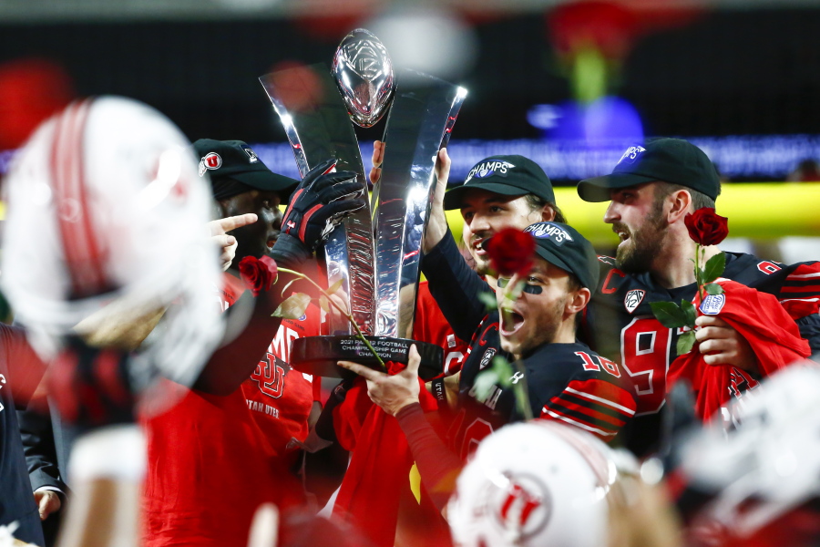 Utah players celebrate with the trophy after their victory over Oregon to win the Pac-12 Conference championship NCAA football game Friday, Dec. 3, 2021, in Las Vegas. The Pac-12 announced, Wednesday, May 18, 2022, it was scrapping its divisional format for the coming season Wednesday, May 18, 2022.