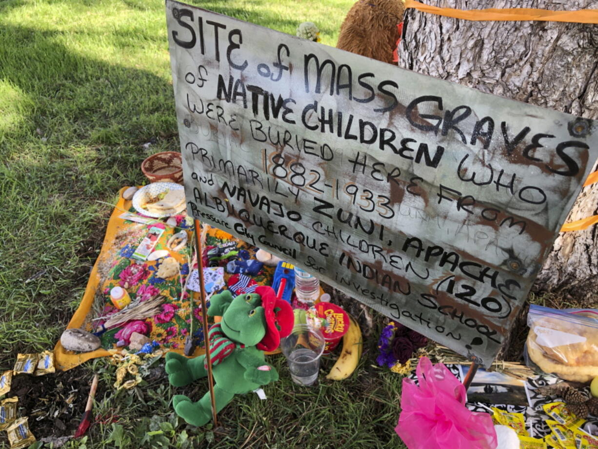 FILE - A makeshift memorial for the dozens of Indigenous children who died more than a century ago while attending a boarding school that was once located nearby is displayed under a tree at a public park in Albuquerque, N.M., on  July 1, 2021. The U.S. Interior Department is expected to release a report Wednesday, May 11, 2022, that it says will begin to uncover the truth about the federal government's past oversight of Native American boarding schools.