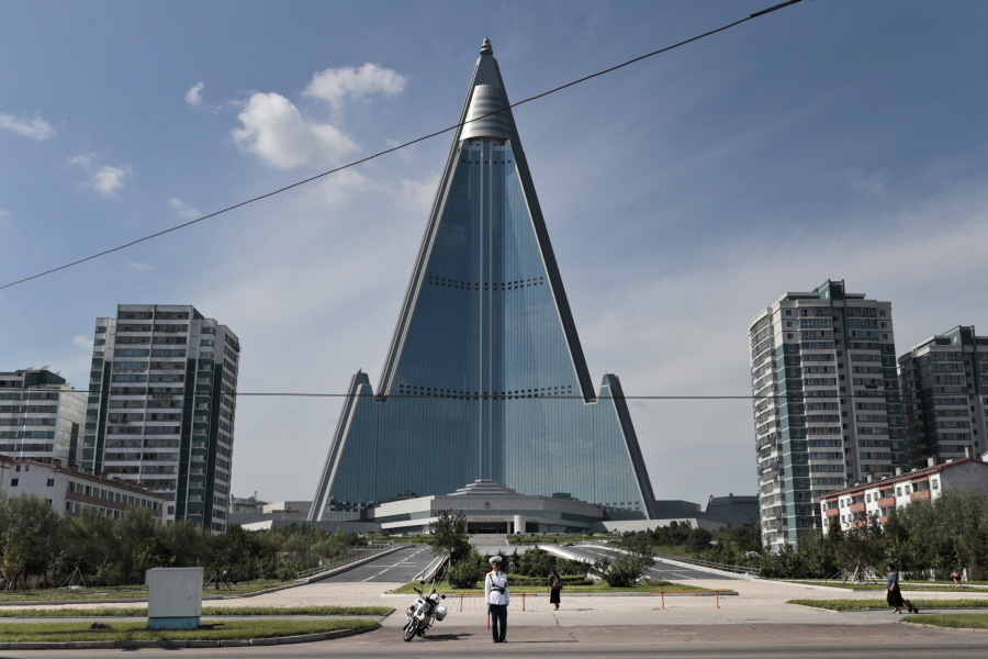 FILE - A traffic officer is dwarfed by the 105-story Ryugyong Hotel in Pyongyang, North Korea, Wednesday, Sept. 11, 2019. U.S. President Joe Biden met Monday, May 23, 2022, while visiting Japan with families of citizens abducted by North Korea decades ago to show his support for their efforts to win the return of their loved ones.