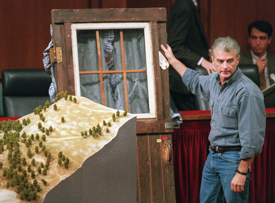 FILE - Randy Weaver holds the door of his cabin showing holes from bullets fired during the 1992 siege of his Ruby Ridge, Idaho, home, model at left, during testimony before the Senate Judiciary Subcommittee on Capitol Hill in Washington on Sept. 6, 1995. Weaver had died at the age of 74. The Ruby Ridge standoff left three people dead and served as a spark for the growth of anti-government extremists.