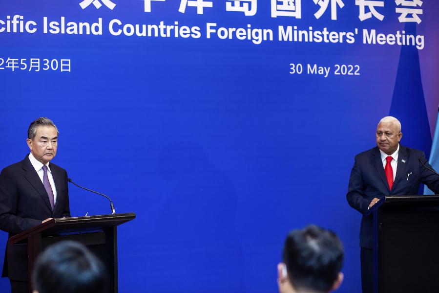 China's Foreign Minister Wang Yi, left, appears on stage at the Pacific Islands Foreign Ministers' meeting with Fiji's Prime Minister Frank Bainimarama, Monday, May 30, 2022, in Suva, Fiji.