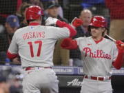 Philadelphia Phillies' Rhys Hoskins (17) is greeted by Bryson Stott, right, after hitting a solo home run against the Seattle Mariners, Monday in Seattle. (Ted S.
