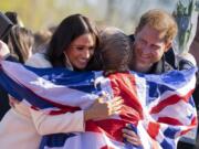 Prince Harry and Meghan Markle, Duke and Duchess of Sussex, hug Lisa Johnston, a former army medic and amputee, who celebrates with her medal at the Invictus Games venue in The Hague, Netherlands on April 17.