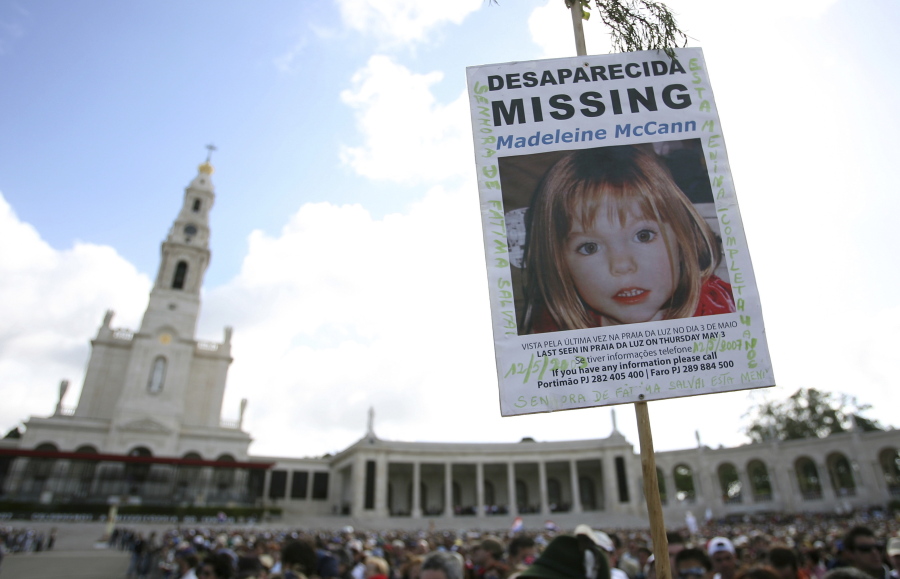 FILE - A picture of missing British girl Madeleine McCann, who disapeared from the Praia da Luz beach resort in the Algarve, is displayed at Our Lady of Fatima shrine Sunday, May 13 2007, in Fatima, northern Portugal.   The parents of Madeleine McCann, a British toddler who vanished from an apartment during her family's vacation in Portugal 15 years ago and captured global interest, say they remain hopeful that efforts by police in three countries to solve the mystery will eventually bring answers. Kate and Gerry McCann, both British doctors living in England, said in a statement to mark the anniversary of their daughter's disappearance Tuesday, May 3, 2022 that "a truly horrific crime" was committed in 2007.