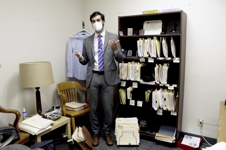 FILE - Public defender Drew Flood with the nonprofit law firm Metropolitan Public Defender looks his files for the criminal cases he is currently working on in Portland, Ore., on May 5, 2022.