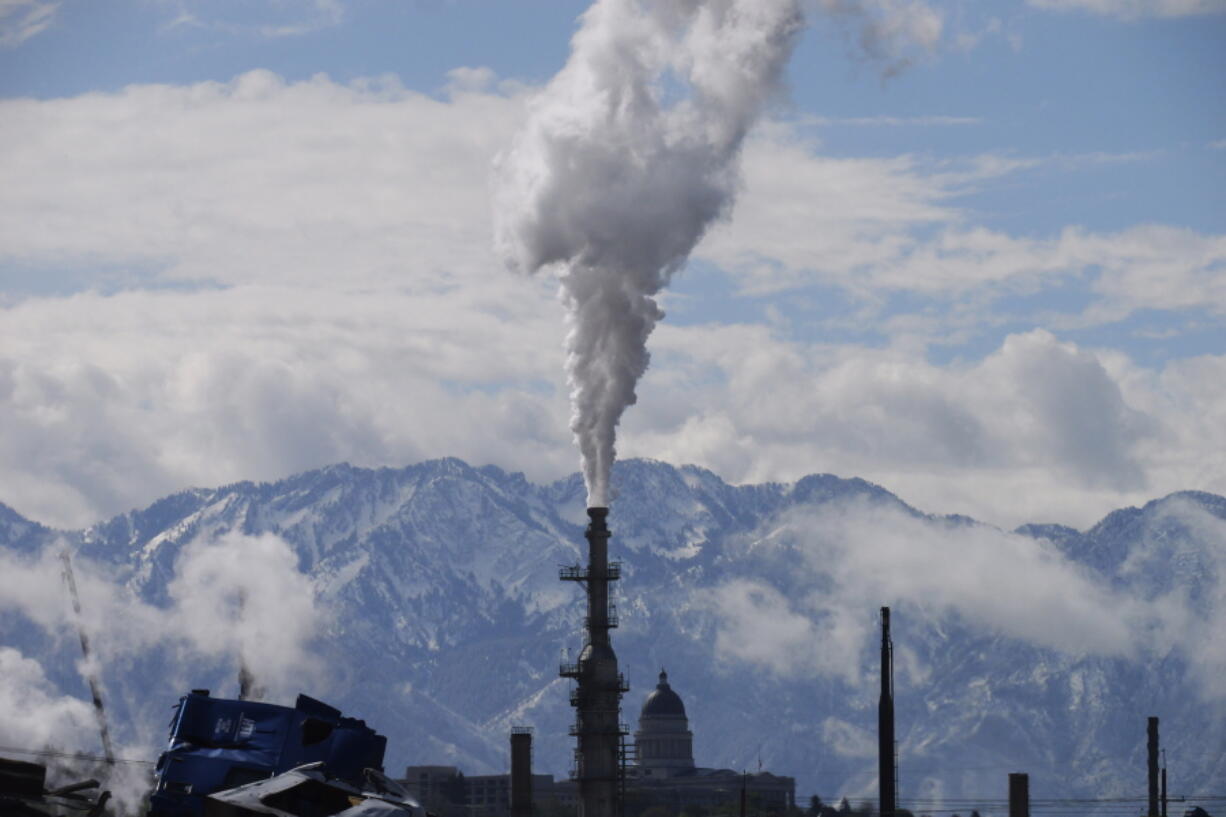 The Utah State Capitol, rear, is shown behind an oil refinery on Thursday, May 12, 2022, in Salt Lake City. A growing number of Republican-led states with economies that rely heavily on fossil fuels are pushing back against shifts in the financial industry to consider new factors such as environmental risk in their investment decisions.