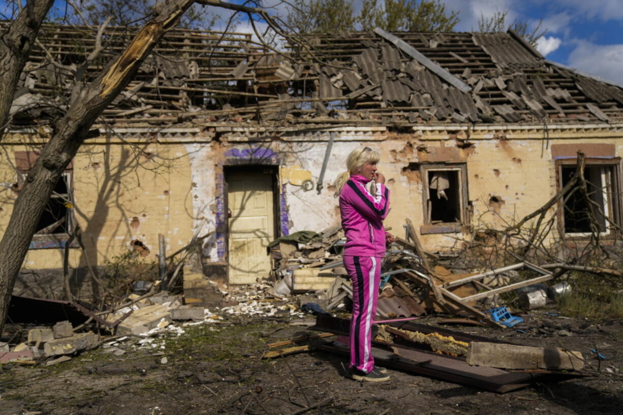 Iryna Martsyniuk, 50, stands next to her house, heavily damaged after a Russian bombing in Velyka Kostromka village, Ukraine, Thursday, May 19, 2022. Martsyniuk and her three young children were at home when the attack occurred in the village, a few kilometres from the front lines, but they all survived unharmed.