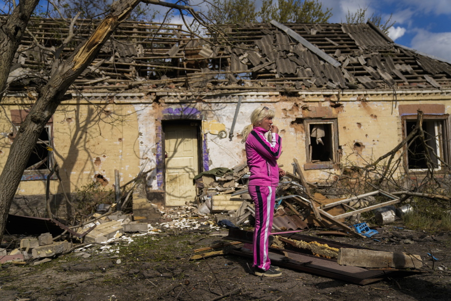 Iryna Martsyniuk, 50, stands next to her house, heavily damaged after a Russian bombing in Velyka Kostromka village, Ukraine, Thursday, May 19, 2022. Martsyniuk and her three young children were at home when the attack occurred in the village, a few kilometres from the front lines, but they all survived unharmed.