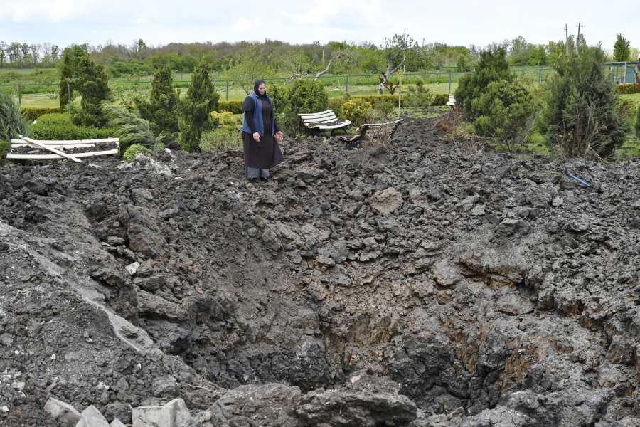 Orthodox Sister Evdokia gestures in front of the crater of an explosion, after Russian shelling next to the Orthodox Skete in honour of St. John of Shanghai in Adamivka, near Slovyansk, Donetsk region, Ukraine, Tuesday, May 10, 2022.