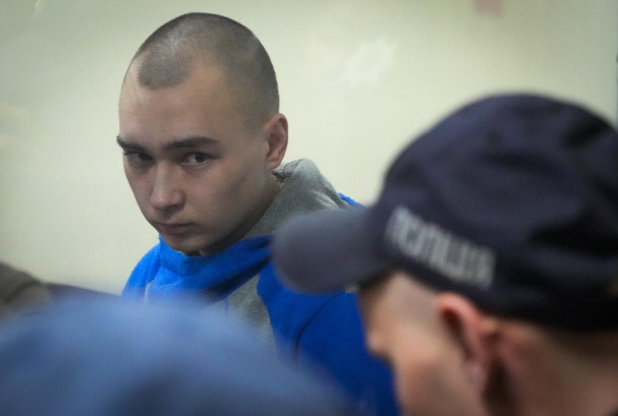 Russian army Sergeant Vadim Shishimarin, 21, is seen behind a glass during a court hearing in Kyiv, Ukraine, Wednesday, May 18, 2022. The Russian soldier has gone on trial in Ukraine for the killing of an unarmed civilian. The case that opened in Kyiv marked the first time a member of the Russian military has been prosecuted for a war crime since Russia invaded Ukraine 11 weeks ago.