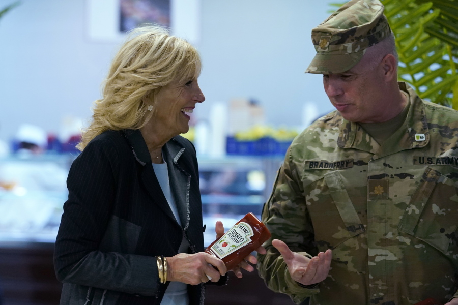First lady Jill Biden, left, gives bottles of ketchup to Major Shawn Bradberry, U.S. Army Deputy Host Nation Advisor for Romania, right, during her visit to the Mihail Kogalniceanu Air Base in Romania, Friday, May 6, 2022. The base was out of ketchup. Biden also served meals to and visit with some of the U.S. troops assigned to the base during her visit.