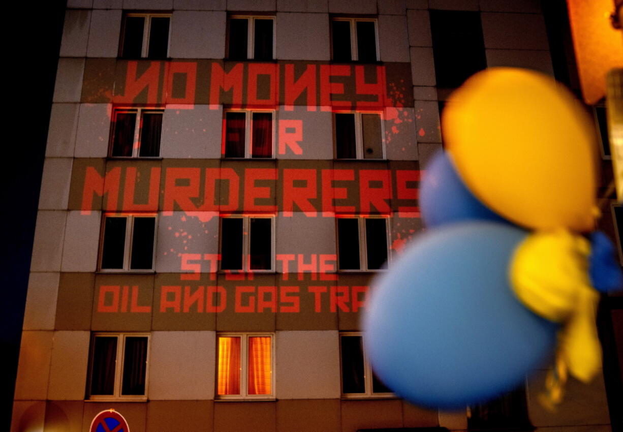 FILE - The words "No Money for Murderers, Stop the Oil and Gas Trade" are projected by activists onto the Russian consulate in Frankfurt, Germany, April 4, 2022. Europe is discussing a boycott of Russian oil over the Kremlin's invasion of Ukraine. As Russia's biggest customer for oil, the 27-country European Union could deal a blow to President Vladimir Putin's state finances. But Europe would face higher prices and such a move would send an oil shock through a global economy that's still rebounding from the COVID-19 pandemic.