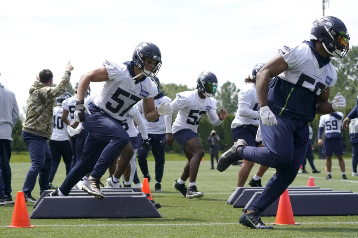 Seattle Seahawks linebackers Cody Barton (57) and Jordan Brooks, right, run a drill during NFL football practice Monday, May 23, 2022, in Renton, Wash. (AP Photo/Ted S.
