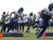 Seattle Seahawks linebackers Cody Barton (57) and Jordan Brooks, right, run a drill during NFL football practice Monday, May 23, 2022, in Renton, Wash. (AP Photo/Ted S.