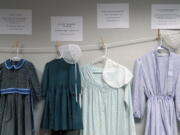 Dresses donated by sexual assault survivors from Amish and other plain-dressing religious groups hang on a clothesline beneath a description of each survivors' age and church affiliation, on Friday, April 29, 2022, in Leola, Pa. The exhibit's purpose was to show that sexual assault is a reality among children and adults in such groups. Similar exhibits held nationwide aim to shatter the myth that abuse is caused by a victim's clothing choice.
