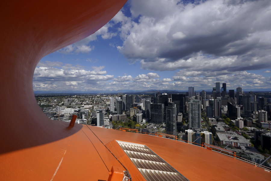 Downtown Seattle is framed by the curved roof of the Space Needle, Tuesday, May 10, 2022, in Seattle. The roof of the Seattle icon has been painted its original color of "galaxy gold," in honor of the attraction's 60th anniversary and the color will remain for the coming year. (AP Photo/Ted S.