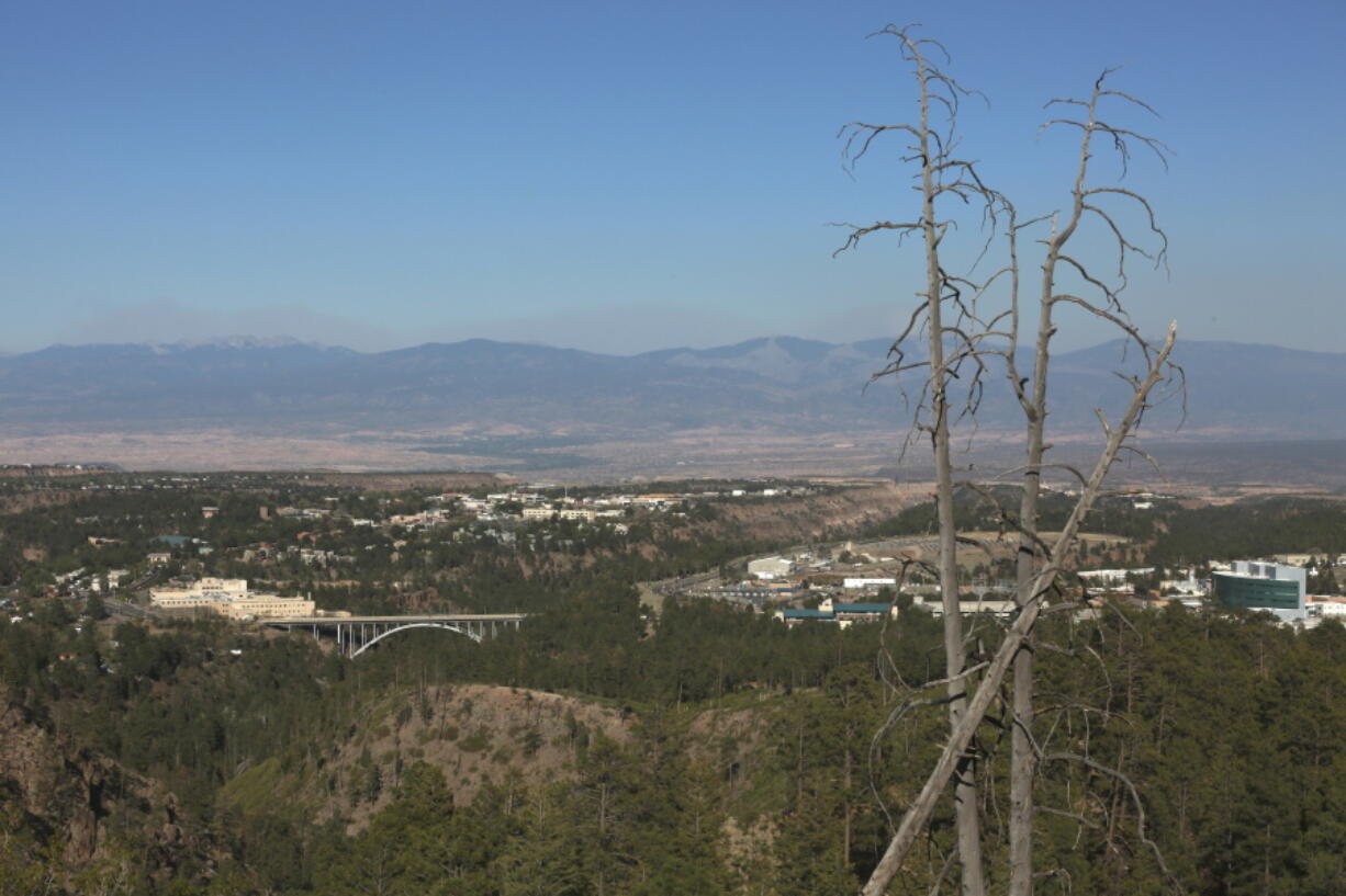 A haze of wildfire smoke hangs over the Upper Rio Grande valley behind the mesa-top city of Los Alamos, N.M., on Thursday, May 12, 2022. Public schools and many businesses were closed as a wildfire crept closer to the city and companion national security laboratory. Scientists at Los Alamos National Laboratory are using supercomputers and ingenuity to improve wildfire forecasting and forest management amid drought and climate change in the American West.