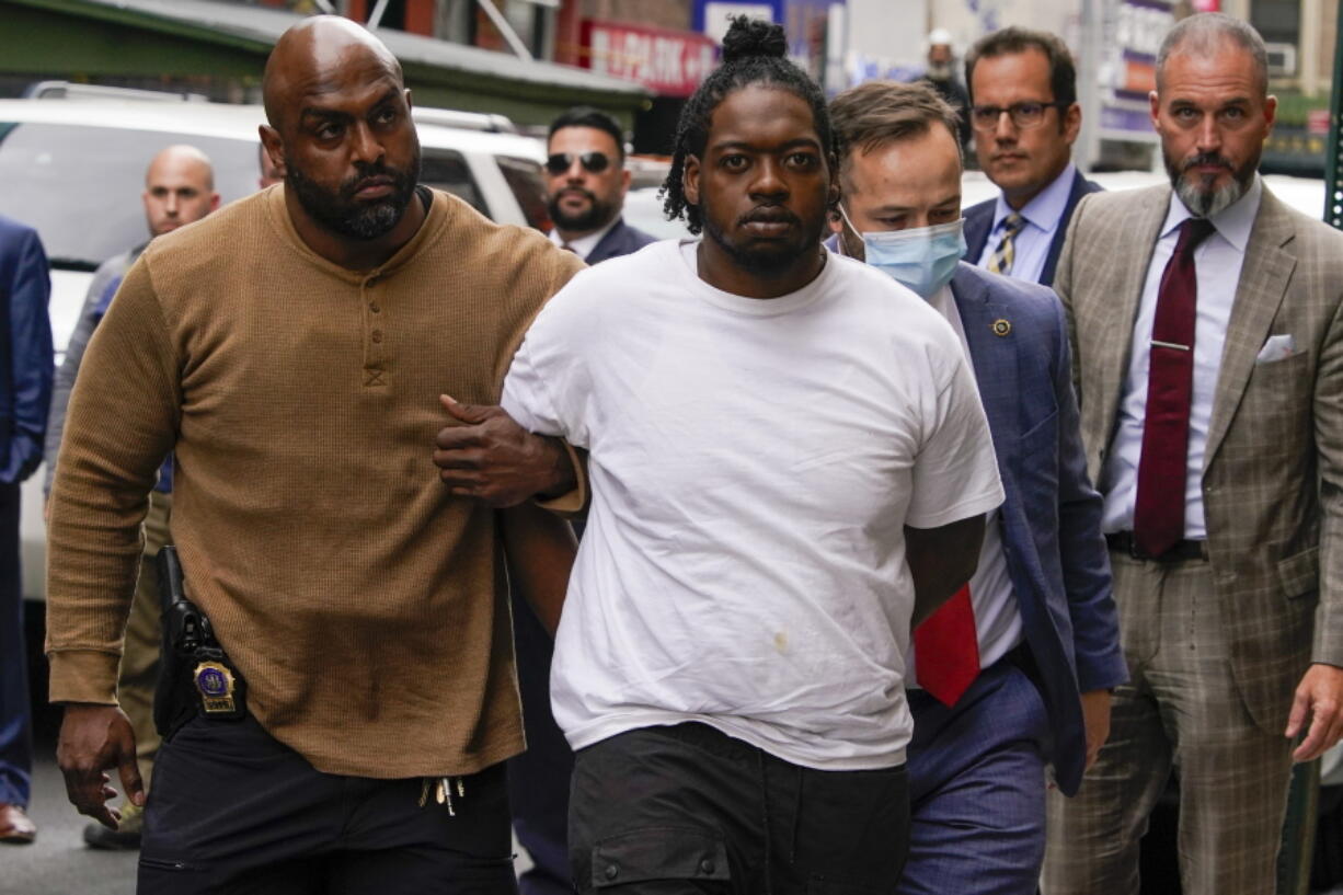Andrew Abdullah is escorted into the Fifth precinct, Tuesday, May 24, 2022, in New York.  Abdullah, the man wanted in an apparently unprovoked fatal shooting aboard a New York City subway train surrendered to police on Tuesday, hours after authorities posted his name and photo on social media and implored the public to help find him.