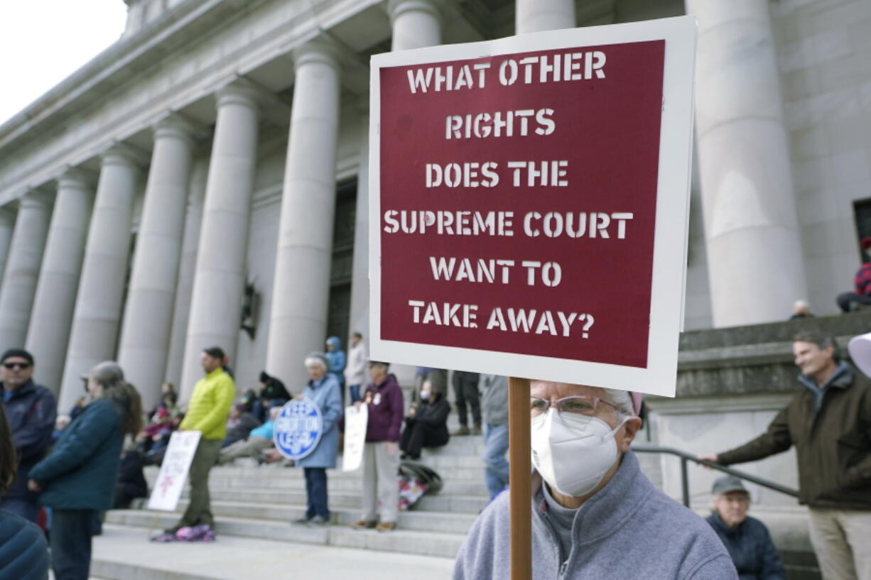 FILE - A person holds a sign referencing the U.S. Supreme Court as they take part in a rally in favor of abortion rights on the steps of the Temple of Justice, which houses the Washington state Supreme Court, Tuesday, May 3, 2022, at the Capitol in Olympia, Wash. (AP Photo/Ted S.