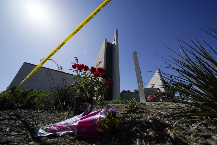 FILE - Flowers sit outside crime scene tape at Geneva Presbyterian Church on May 17, 2022, in Laguna Woods, Calif., where a shooting at the church on Sunday left one dead and five injured. Officials in California's Orange County are still trying to determine why a gunman opened fire in the church.