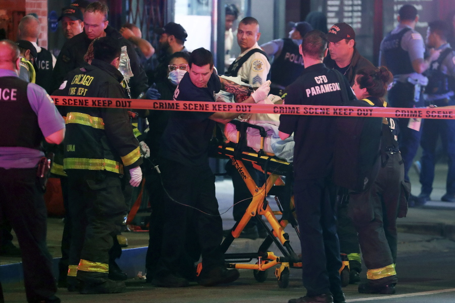 First responders move a shooting victim to an ambulance on Adams Street near State Street in downtown Chicago on Saturday, May 14, 2022.