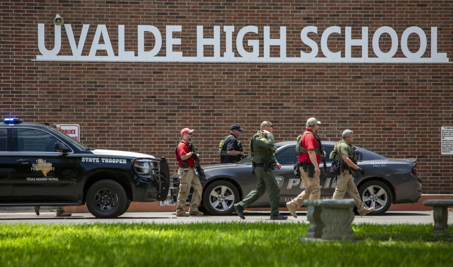 Law enforcement personnel walk outside Uvalde High School after shooting a was reported earlier in the day at Robb Elementary School, Tuesday, May 24, 2022, in Uvalde, Texas.