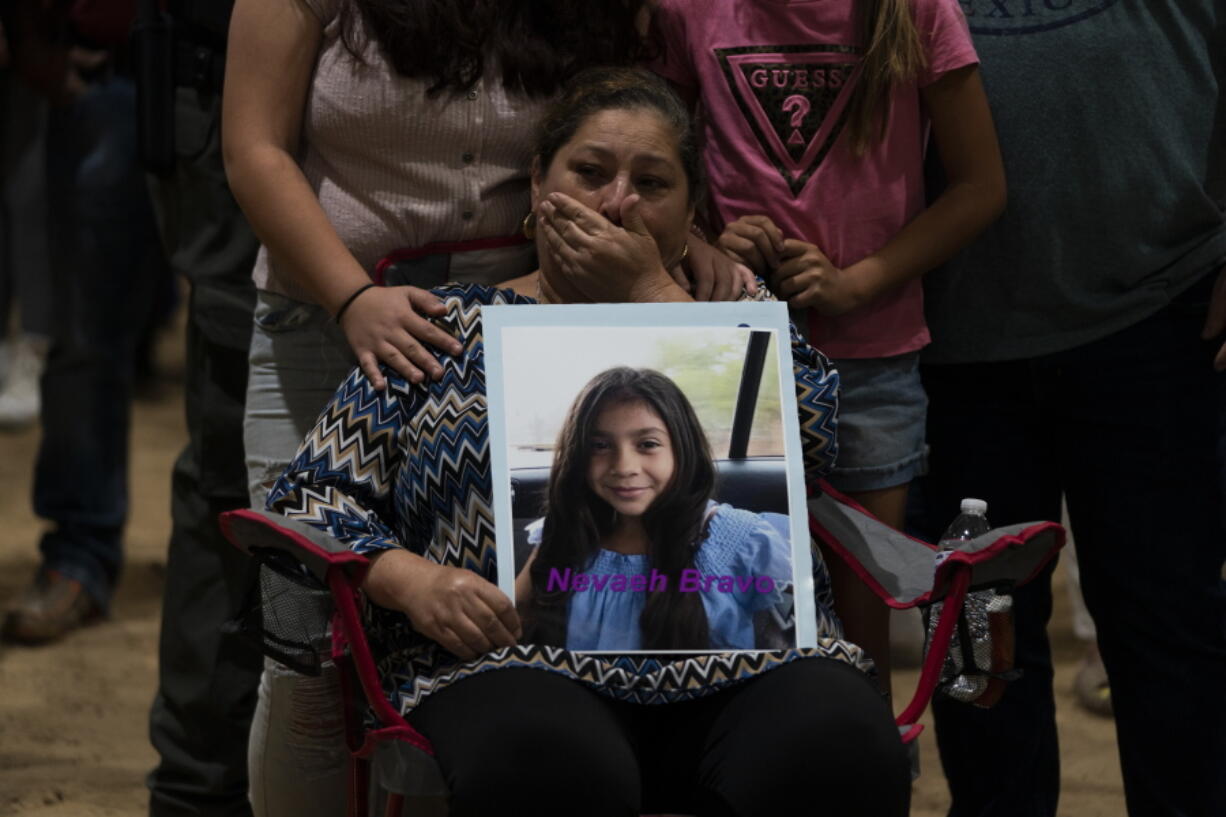 Esmeralda Bravo, 63, sheds tears while holding a photo of her granddaughter, Nevaeh, one of the Robb Elementary School shooting victims, during a prayer vigil in Uvalde, Texas, Wednesday, May 25, 2022. (AP Photo/Jae C.