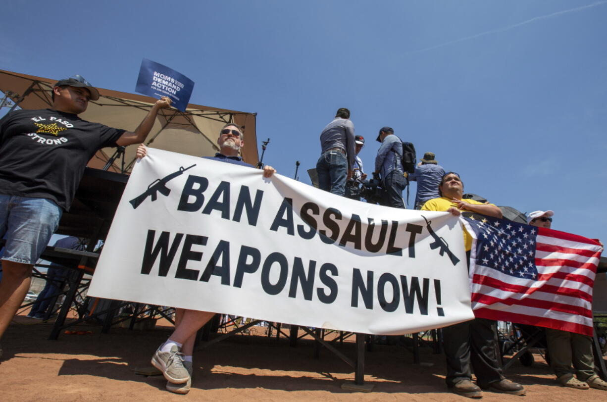 FILE - Demonstrators hold a banner to protest the visit of President Donald Trump to the border city after the Aug. 3 mass shooting in El Paso, Texas, on Aug. 7, 2019. A gunman killing multiple elementary school children and adults in Texas on Tuesday, May 24, 2022, adds to the state's grim recent history of mass shootings.