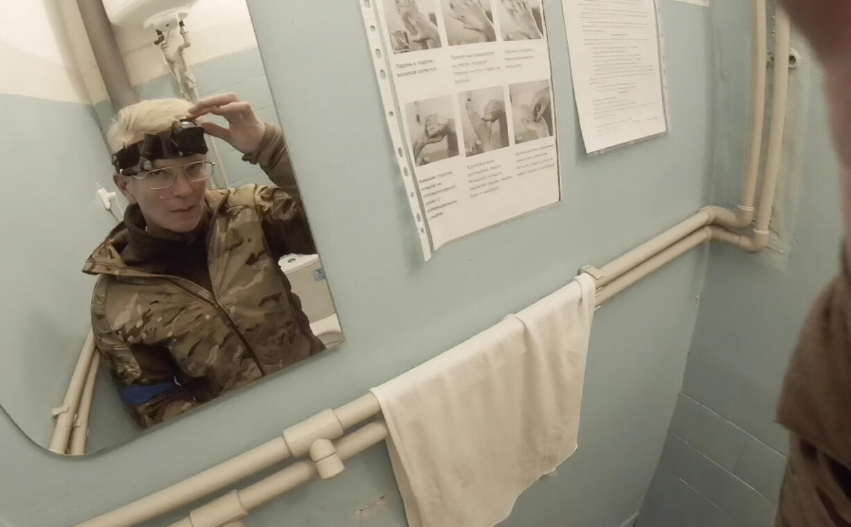 Yuliia Paievska, known as Taira, looks in the mirror and turns off her camera in Mariupol, Ukraine on Feb. 27, 2022. Using a body camera, she recorded her team's frantic efforts to bring people back from the brink of death.